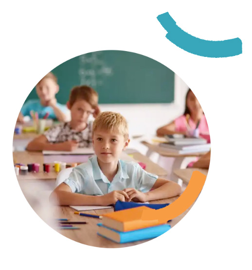 Young boy sitting at a desk in a classroom.