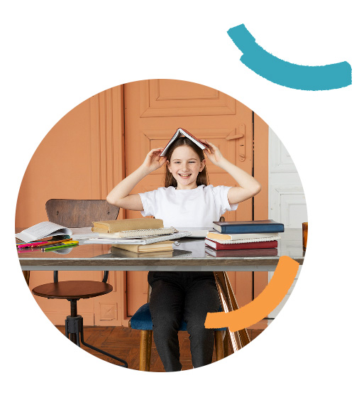 Girl sitting at desk with book on head